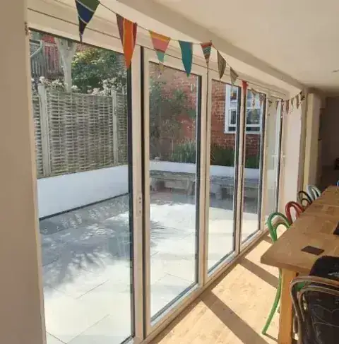 Arkay aluminium bifold doors opening onto a garden, supplied by Tradesupply Windows